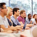 A diverse group of students attentively listening in a classroom setting
