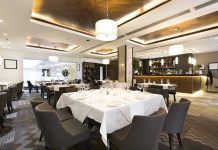 Glitching Robot ERUPTS Inside Hot Pot Interior of a modern restaurant with elegantly set tables and a bar area