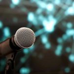 Music Industry SHOCKED: AI Artist Tops Charts Microphone with abstract, blurred blue background.