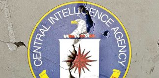 Cracked CIA logo on weathered wall.