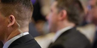 Security personnel with earpiece in a suit.