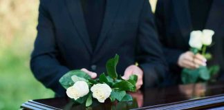 Protesters Hunt Kash Patel at Private Funeral People placing white roses on a casket.