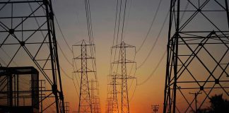 10 Million Households in Merger Crossfire: Will Rates SPIKE? Transmission towers at sunset.
