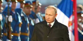 Putin’s Shocking Claim: War Nears End A man in dark coat at a military event.