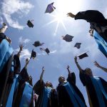 AI Graduation Speech Chaos: Google’s Former CEO Booed Off Stage Graduating students celebrating by throwing their caps into the air under a bright blue sky
