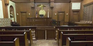 Justice Resigns Over Explosive Cheating Allegations! Interior view of an empty courtroom with wooden benches and a judges bench