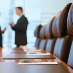 OpenAI Chief’s Investments Spark Turmoil Two business professionals engaged in conversation in a conference room