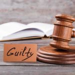 Jury SLAMS Actor — Dark Past Unveiled! A wooden gavel next to a card that reads 'Guilty' and an open book