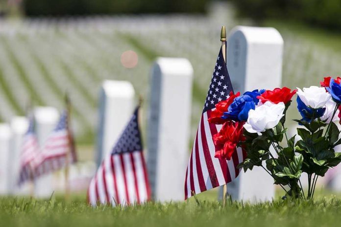 shutterstock_195247490 American flags and flowers placed at graves in a cemetery
