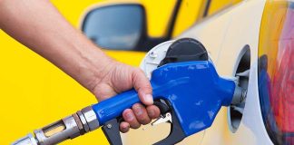 Trump’s Stunning Gas Tax Reversal A person refueling a car at a gas station with a blue nozzle
