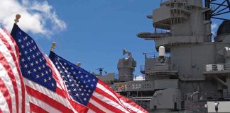 SURPRISE Attacks – U.S. Battles Iran in Ceasefire Chaos American flags in front of a naval ship under a blue sky