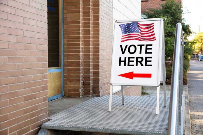 Vote Here sign with arrow and American flag.