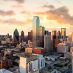 City skyline at sunset with modern skyscrapers.