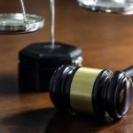 Taliban Commander Caged — Shocking U.S. Twist Gavel and scales of justice on wooden table.