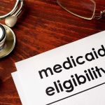 FBI Nabs Fugitive Behind $1.2B Medicare Grift Stethoscope pen document about Medicaid eligibility on table