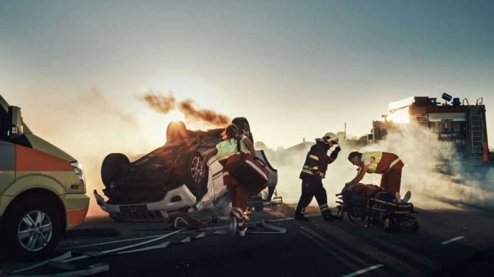 car-crash-traffic-accident-scene1721662795jpg Emergency responders at an overturned, smoking car on a roadway