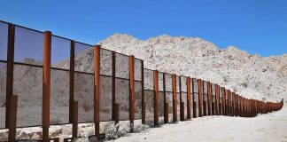 Cartel Super-Tunnel Found Under U.S. Port A long border wall stretches across a desert landscape with mountains in the background