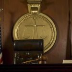 Former Top Insider Bombshell: Plea Deal Over Classified Files A judges bench in a courtroom with a gavel and legal symbols