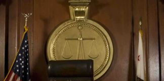 A judges bench in a courtroom with a gavel and legal symbols