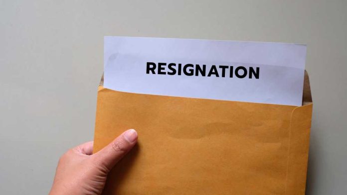 shutterstock_1791243959 A hand holding an envelope with a resignation letter partially visible