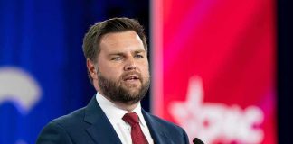 JCPOA 2.0? JD Vance Dares Critics A man in a suit delivering a speech at a conference