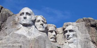 Media Torches Patriotic Push Mount Rushmore with four presidential faces carved in rock.