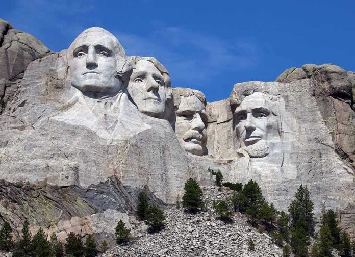 113115559 Mount Rushmore with four presidential faces carved in rock.