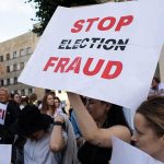 Election Referees Axed Weeks Before Voting People holding Stop Election Fraud protest signs.