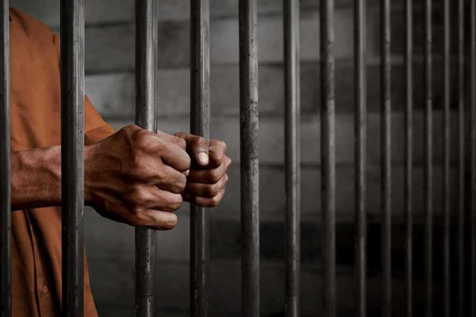 772489252 Hands gripping prison cell bars.