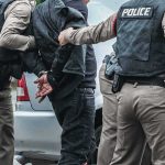Most Wanted Down — Predawn Ambush Police officers arresting a person beside a car