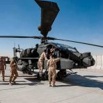 Iran Strikes U.S. Base—Troops Killed Soldiers inspect a military attack helicopter on a tarmac