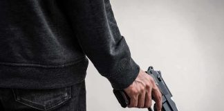 Mexico Town Hall Turned Killing Ground person holding a handgun at their side