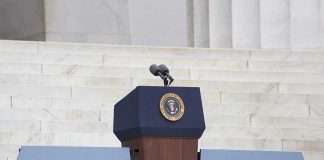 Trump Axes Rules, Then Pardons? Critics Howl Podium with a microphone and presidential seal in front of steps