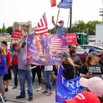 37-0? Inside Trump’s Scoreboard Crowd of people at a political rally holding flags and signs