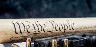 July 4 Showdown: Guns vs. Liberty Gun, bullets, Constitution scroll on American flag.