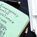 Fauci Ego Log? New Bombshell Notebook titled Emergency Rental Assistance Program beside papers and pen