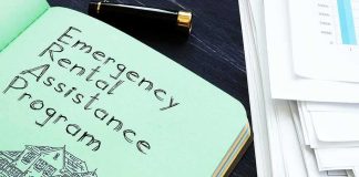 Notebook titled Emergency Rental Assistance Program beside papers and pen