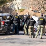 Mother Dead- Identity Firestorm Sparked Police and sheriff officers gather around vehicles on a suburban street