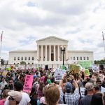 Cuba-Linked Protests Target U.S. Bases Crowd of protesters outside a neoclassical courthouse holding signs