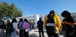School Overdoses Explode — Silence Follows Students standing outside a high school entrance
