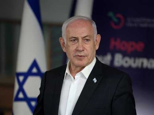 shutterstock_2644835535 A political leader speaking at a press conference with the Israeli flag in the background