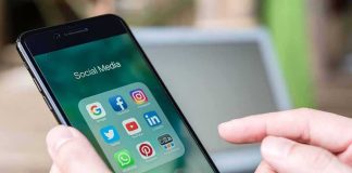 Hands holding a smartphone with social media apps on screen