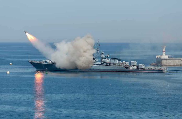 shutterstock_533229181 Warship launching a missile at sea