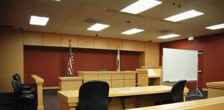 Pop Star’s Alleged Grooming Turns Deadly Interior view of an empty courtroom with wooden furniture and American flags