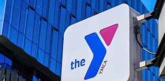 Gender Policy Vanishes — Why Now? YMCA sign mounted on a modern glass building
