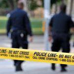 Burglar Shot — Then Drops $10M Bomb Police officers walking past caution tape at a crime scene