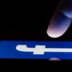 Record Meta Penalty — And It’s Not Over finger hovering over Facebook app icon on a smartphone screen