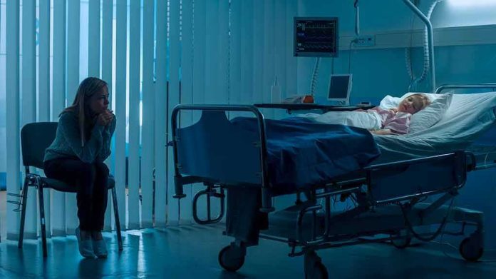 shutterstock_1181842819 hospital room with child in bed and adult sitting nearby