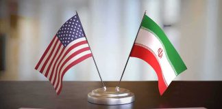 Payback Play: Trump Corners Tehran United States and Iran desk flags on a stand
