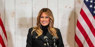 Melania’s Back-Channel With Putin? woman speaking at podium with microphones and US flags
